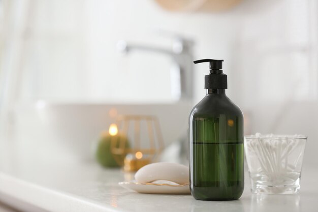 green soap dispenser on white countertop in bathroom space for text