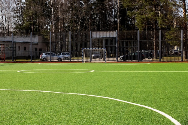 Green soccer field behind the fence closeup