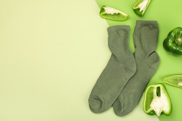 Зеленые носки и болгарский перец на двухцветном фоне