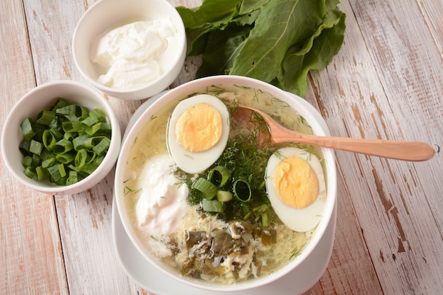 Green sorrel and spinach soup with boiled egg spring onion and sour cream