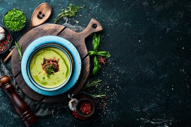 Green soup with bacon soup with broccoli spinach and green peas\
top view rustic style