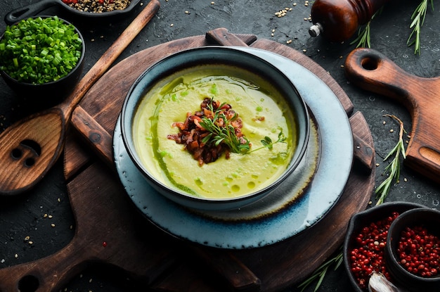 Green soup with bacon Soup with broccoli spinach and green peas Top view Rustic style