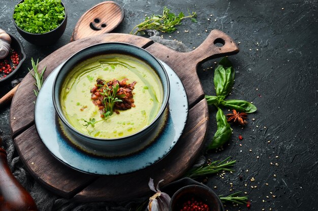 Green soup with bacon Soup with broccoli spinach and green peas Top view Rustic style