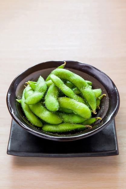 Green soybeans on wooden table