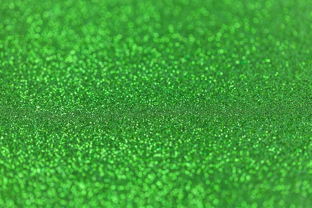 Green sparkling background from small sequins, closeup Brilliant backdrop