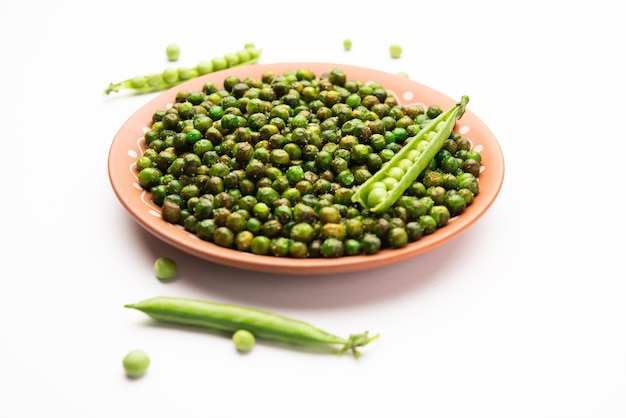 インドでカクテルドリンクと一緒に消費されるグリーンスパイシーエンドウ豆の揚げ物またはローストナムキーン、ドライスナックまたはチャクナ
