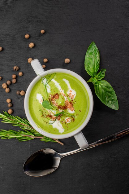 Green spinach cream soup on wooden background