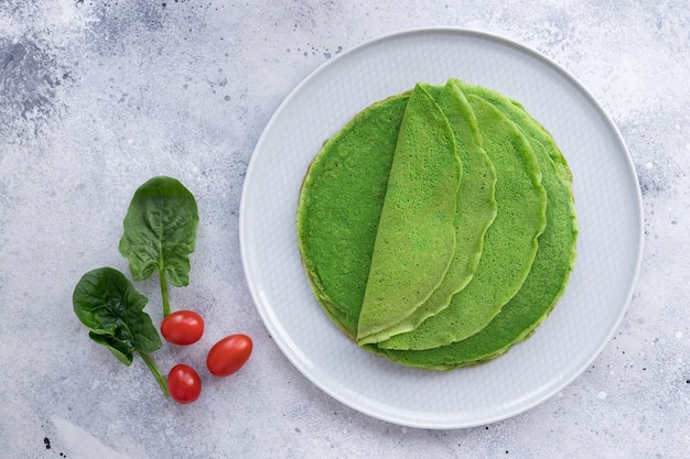 Foto crepes frittelle di spinaci verdi su piatto blu cibo vegano