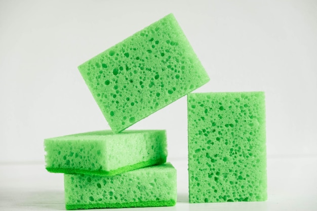 Green sponges for cleaning on a white background