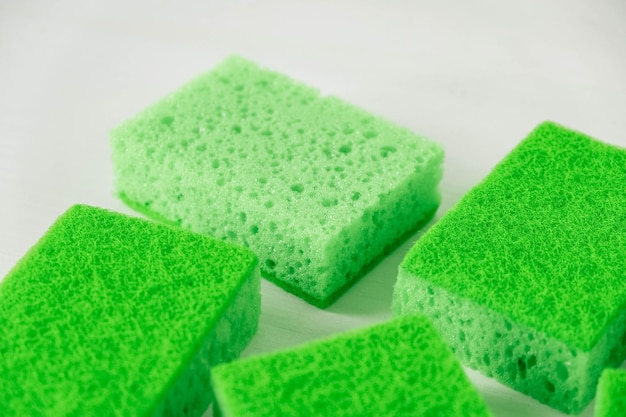 Foto spugne verdi per la pulizia su fondo bianco
