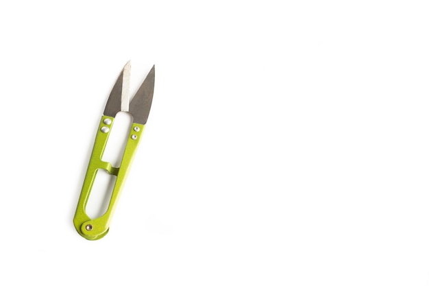 Green stainless steel scissors on a white background with copy space