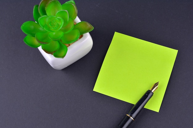 Green sticky note with pen