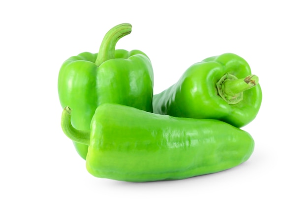 Green sweet peppers on a white surface