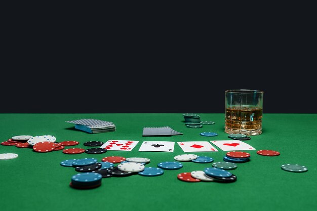 Green table in casino with poker cards and chips.