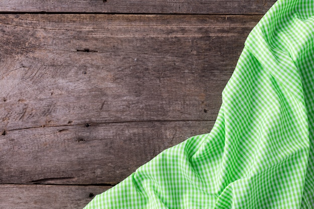 Photo green table cloth on wooden background