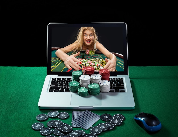 Photo green table with casino chips and cards on notebook