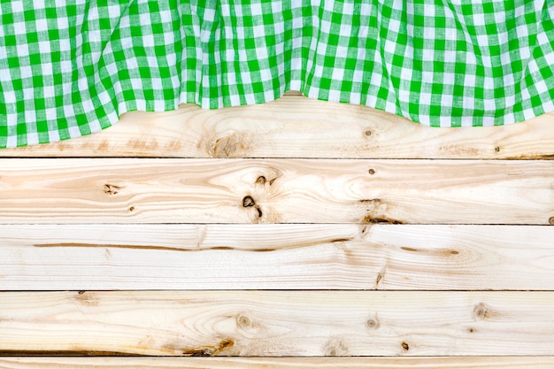 Green tablecloth on wooden table, top view