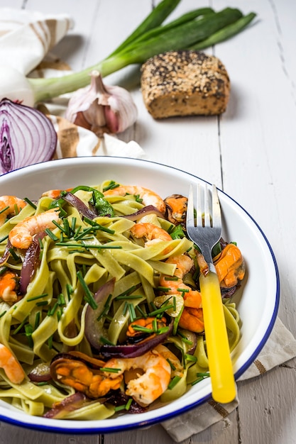 Green tagliatelle with seafood. Mussels; Prawns