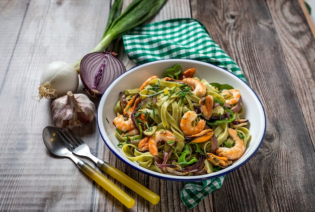 Green tagliatelle with seafood. Mussels; Prawns