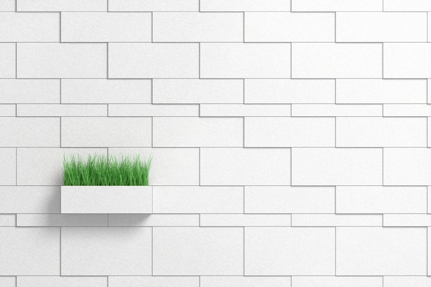 Зеленая высокая трава, высовывающаяся из цветочного горшка в форме кирпича от кирпичной серой стены
