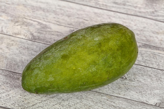 Green tasty mango over wooden background