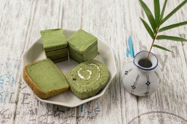 写真 白い皿と花瓶に緑茶パン