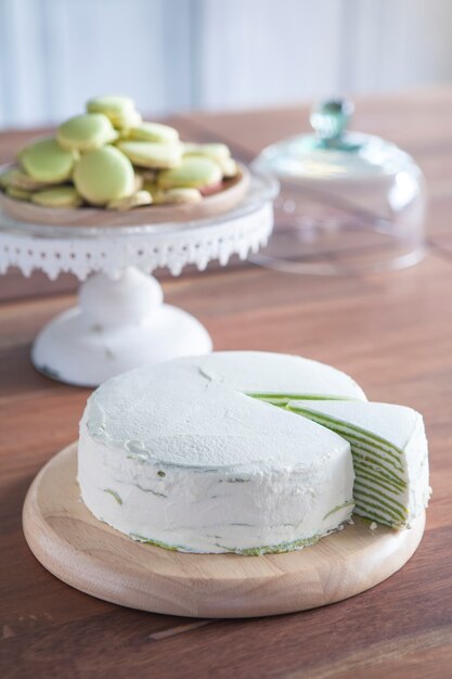 Green Tea Crepe Cake and Macaron on Wooden Table