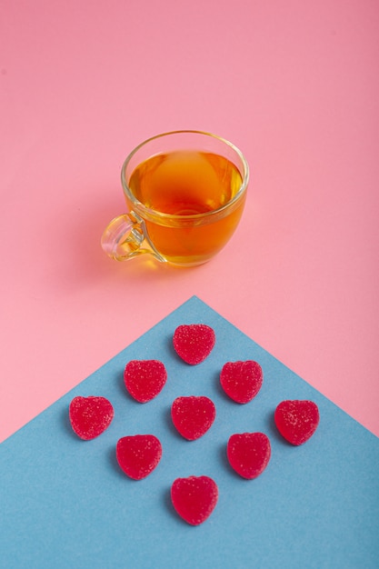 Foto tè verde in una tazza su uno sfondo rosa