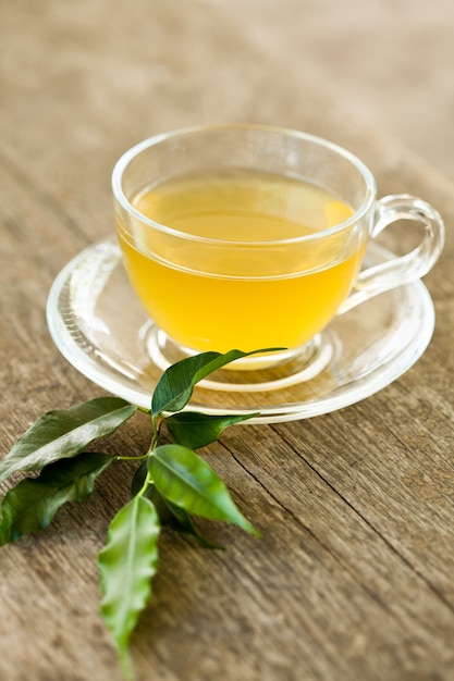 Tè verde in tazza di vetro sulla tavola di legno