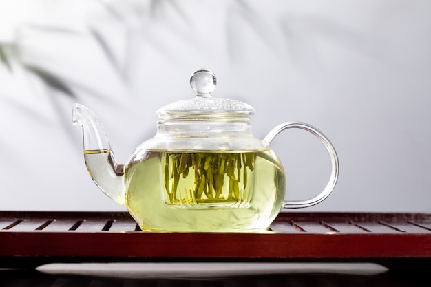 Green tea in glass teapot and cup