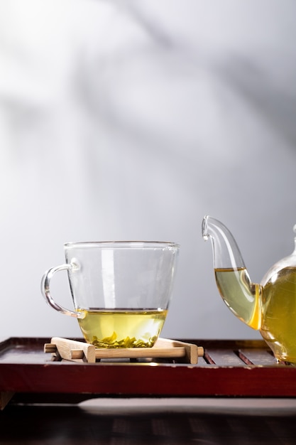 Green tea in glass teapot and cup