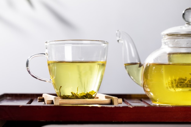 Green tea in glass teapot and cup