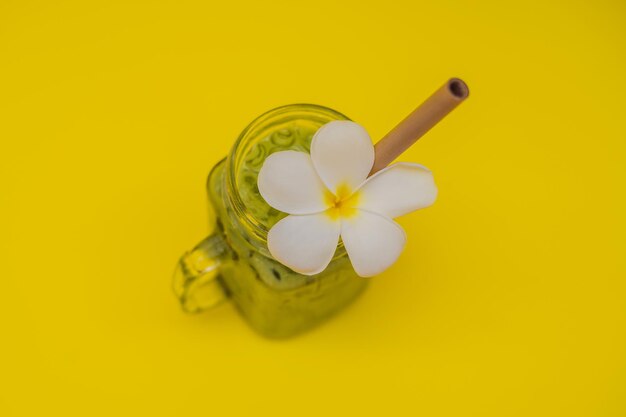 Green tea latte with ice in mason jar and straw on yellow background Homemade Iced Matcha Latte Tea with Milk zero waste