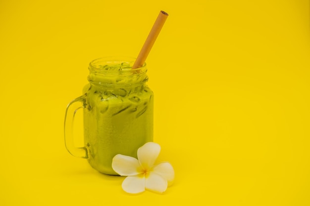 Green tea latte with ice in mason jar and straw on yellow background Homemade Iced Matcha Latte Tea with Milk zero waste