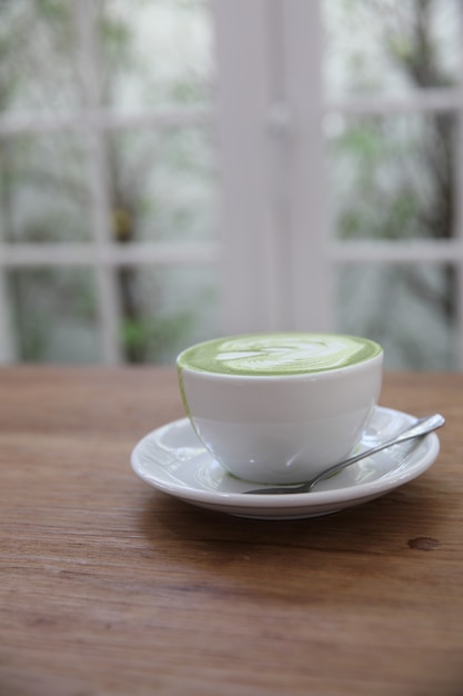 Green tea latte on wood background