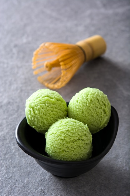 Green tea matcha ice cream scoops on gray stone