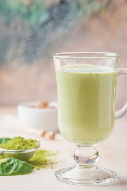 Green tea matcha latte in a glass cup on light background Concept of a healthy diet superfood antioxidant cleansing