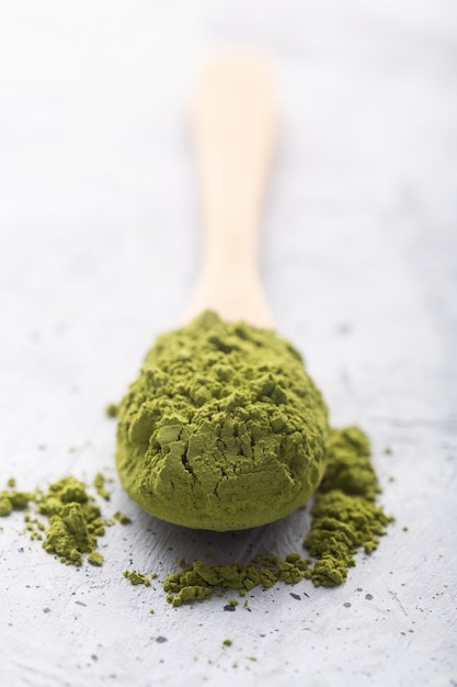 Foto matcha del tè verde in un cucchiaio su superficie di calcestruzzo. colpo da vicino