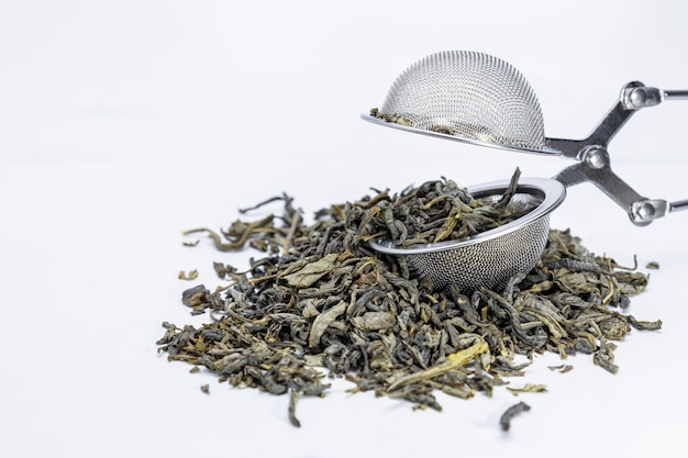 Green tea and sieve, on white background