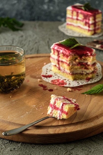 green tea in a transparent cup biscuit with raspberries and cream on a wooden table