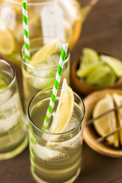 Green tea with citrus in glasses with ice and paper straw.