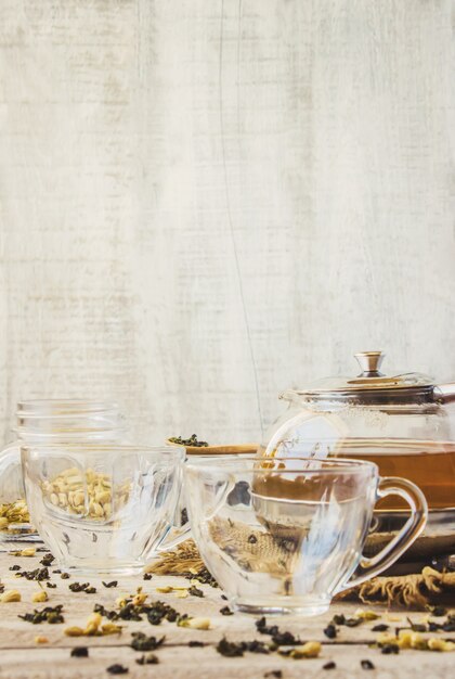 Green tea with Jasmine and black with transparent lemon in a small Cup on a light background. The tea maker. Selective focus.