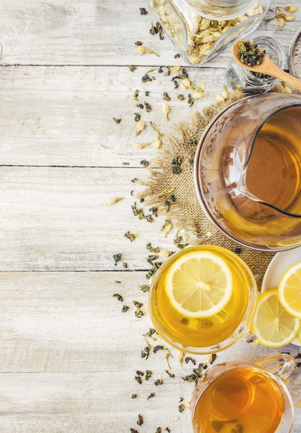 Green tea with Jasmine and black with transparent lemon in a small Cup on a light background. The tea maker. Selective focus.