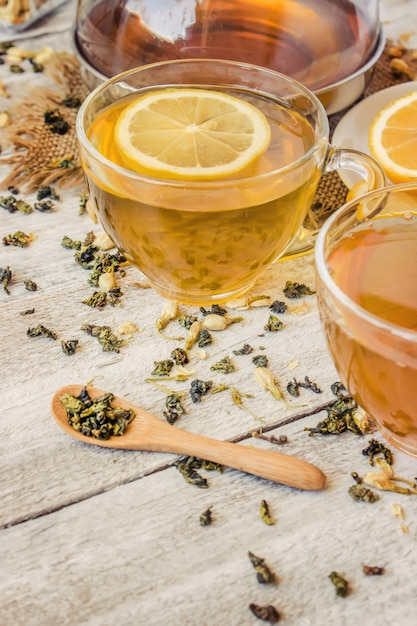 Green tea with Jasmine and black with transparent lemon in a small Cup on a light background. The tea maker. Selective focus.