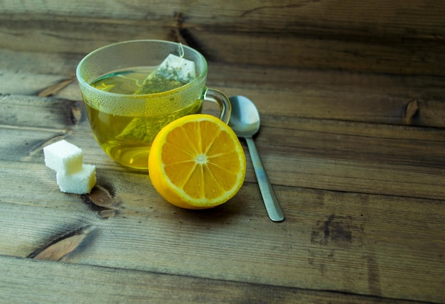 Green tea with lemon in a mug sugar and a spoon