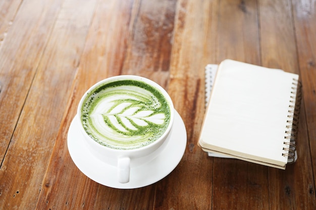 Photo green tea with notebooks on wooden table