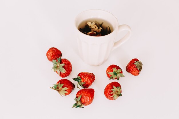 Green tea with strawberries on a white surface Flat lay top view