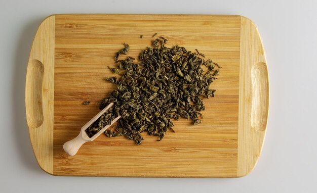 Green tea with susep Background of tea on a kitchen wooden board with a wooden measuring spatula