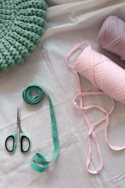 a green thread is on a table with a green needle.