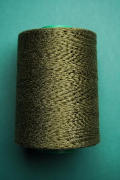 Green thread spool background closeup